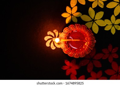 top angle close up of fire-lit clay diya and rangoli art on blac - Shutterstock ID 1674895825