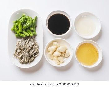 Top angle view of raw shishito Pepper and dried anchovy with four food Ingredients like soy sauce, garlic, oligosaccharide and cooking wine on dish, South Korea
 - Powered by Shutterstock