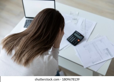 Top back rear head shot view stressed millennial woman feeling confused of banking debt, termination letter while managing home expenditures alone indoors, financial problems bankruptcy concept.