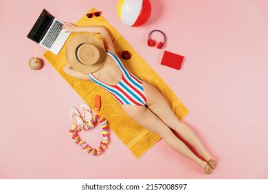 Top back view full body young woman in striped swimsuit lies on towel hotel pool use work laptop pc computer blank screen isolated on plain pink background. Summer vacation sea rest sun tan concept - Powered by Shutterstock