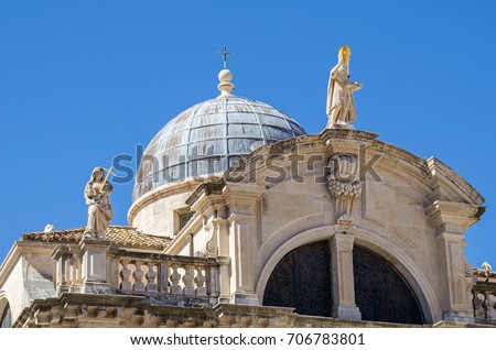 Top of the baroque Church of St.Blaise in the old city of Dubrovnik with the Statue of Saint Blaise, the patron of the city,  and a personifications of Faith to the left on the balustrade. 