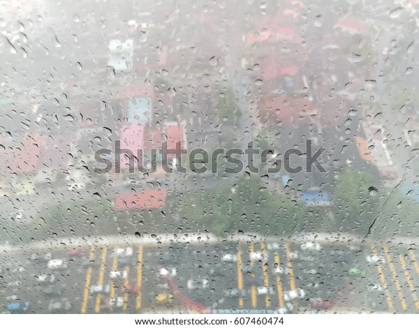 Top bird eyes view through\
the wet glass window of  the traffic jam during raining and rush\
hours