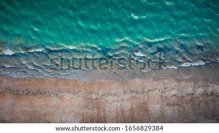 Similar – Luftaufnahme Panoramadrohne Blick auf den blauen Ozean Wellen, die am Sandstrand in Portugal erdrücken.