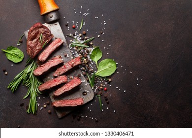 Top blade or denver grilled steak over meat butcher knife. Top view with copy space