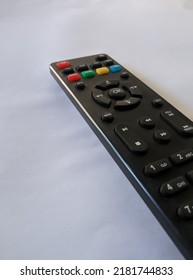 A Top Box Set, Or A Black Television Remote Over The White Background