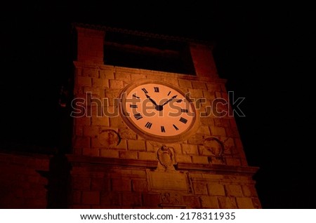 Top of a clock-tower in the night - illuminated
