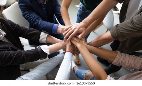 Top close up lot of hands stacked together as symbol concept of teambuilding, loyalty, amity and warm relations between office workers seminar participants, business success celebration, start of work