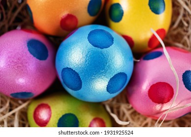 Top close up view of colourful Easter eggs with polka dots in a basket, isolated on white background. Easter celebration concept.