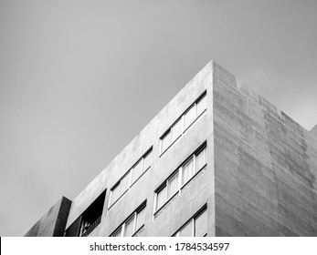 The Top Corner Of A Modern Concrete Building On Cloudy Sky Background, Black And White Tone Style Wit Copy Space.