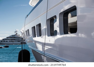 The top deck of a huge yacht at sunny day, glossy board of the boat, The chrome plated handrail, megayacht is moored in port, sun reflection on glossy board