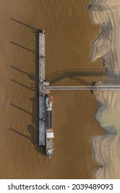 
Top down aerial drone shot of Linkeroever jetty pontoon with boat docked in the river Scheldt. Shadows over water