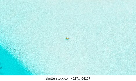 Top Down Aerial Drone View Of Couple On Kayak In Crystal Clear Turquoise Water In The Maldives During Sunny Bright Summer Day 