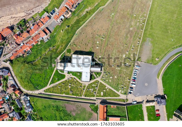 Top down aerial photo of the beautiful town of\
Whitby in the UK in North Yorkshire in the UK showing the Church of\
St Mary  from above