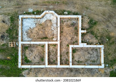 Top down aerial view of building works of new house concrete foundation on construction site.