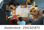 Top down aerial view of business team making scrum task board at meeting room. Group of people writing at paper and sticky notes for making kanban board to manage work flow. Top view. Convocation.