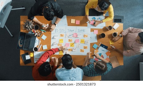 Top down aerial view of business team making scrum task board at meeting room. Group of people writing at paper and sticky notes for making kanban board to manage work flow. Top view. Convocation. - Powered by Shutterstock