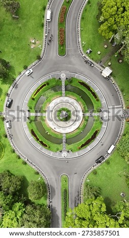 Top Down Aerial View of a Circular Road Roundabout Surrounded by Green Trees