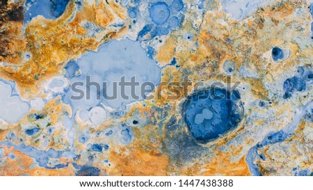 Top down aerial view from drone on geothermal icelandic area in Iceland Seltun near Krysuvik and Kleifarvant lake, blue water and orange colorful ground texture structure hot spring and mud background