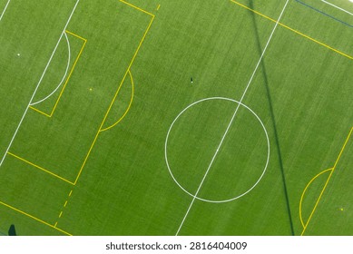 Top down aerial view of an empty green soccer field with white lines