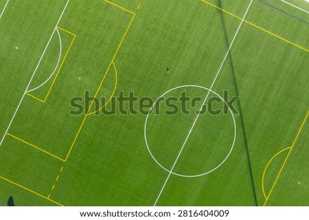 Top down aerial view of an empty green soccer field with white lines