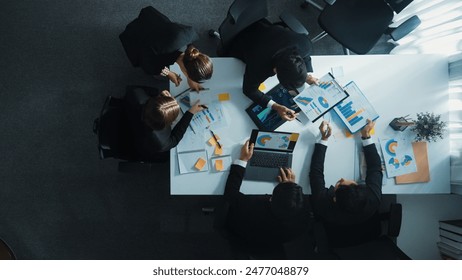 Top down aerial view of manager standing and present marketing plan to skilled investor. Diverse business team working together to analyze financial statistic graph at meeting table. Directorate. - Powered by Shutterstock