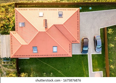 Top Down Aerial View Of A Private House With Red Tiled Roof And Spacious Yard With Parked Two New Cars.