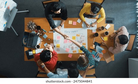 Top down aerial view of professional business people hands making scrum task board to manage workflow in workplace. Diverse smart team shaking hand and making agreement at meeting room. Convocation. - Powered by Shutterstock