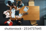 Top down aerial view of smart business people analyze data together at meeting. Group of business team working together and looking at financial chart at tablet placed on meeting table. Convocation.