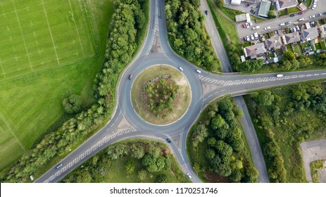 Top down aerial view of a traffic roundabout on a main road in an urban area of the UK