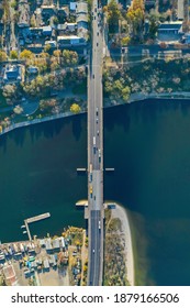 Top Down Aerial View Of The Vehicle Bridge Over The River. Drone Photography. Cars On The Road. City View.