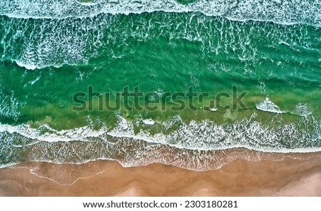 Top down aerial view of the waves on the sandy beach of the Baltic Sea in Poland