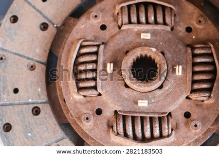 Top down close up of a severely weathered, rusted industrial vehicle clutch disc featuring heavy dampener springs and splined hub.