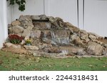 The top down, close up view of a backyard pondless waterfall that has been installed. Dirt patches have been left to add landscaping.