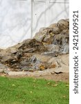 The top down, close up view of a backyard pondless waterfall that has been installed. Dirt patches have been left to add landscaping.