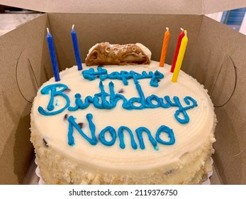 The Top Down, Close Up View Of A Birthday Cake That Is Still In The Cardboard Box From The Bakery. The Cake Reads 