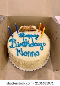 The Top Down, Close Up View Of A Birthday Cake That Is Still In The Cardboard Box From The Bakery. The Cake Reads 