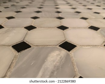 The Top Down, Close Up View Of A Unique Pattern On A Tile Floor. The Small, Gray Tiles Are Square And Are Separated With Tinier, Black, Diamond Tiles.