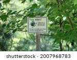 The top down, close up view warning patrons of the public to beware of ticks. The sign says "Tick Alert! Ticks live in grasses and low shrubs. Remain on trails and check yourself before leaving."