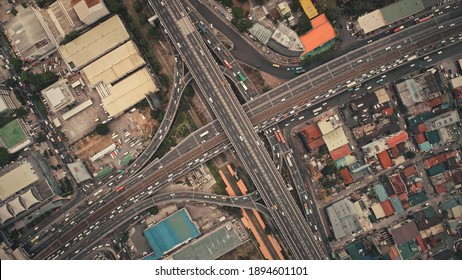 Top down of cross road traffic with cars, trucks, vehicles in aerial view. Downtown of Manila city with colorful buildings roofs at roadside. Philippines urban lifestyle with local journey