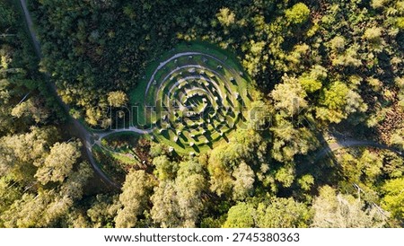 Top down drone perspective of a stone labyrinth in a forest clearing, Scotland