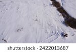 Top down drone photo. Lone man going throw snowed field