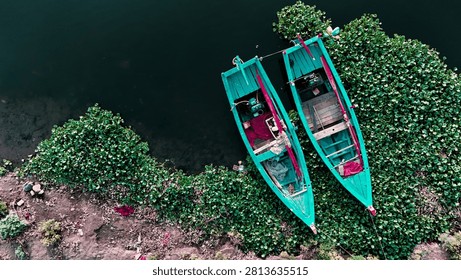 Top Down Drone View of Two Wooden Boats Floating Near Green Aquatic Vegetation