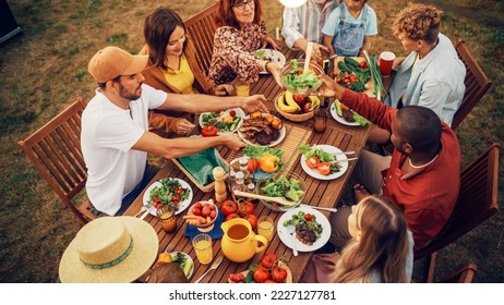 Top Down Elevated View at a Family and Friends Celebrating Outside at Home. Diverse Group of Children, Adults and Seniors Sitting at a Table, Having Fun Conversations. Eating Barbecue and Vegetables. - Powered by Shutterstock