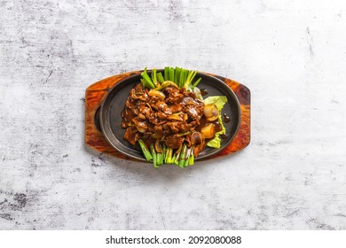 Top Down Flat Lay Asian Cooked Chinese Asia Food On Table. Stir Fried Venison Deer Meat With Ginger And Spring Onion On Hot Plate. Negative Space On Both Side Of Dish.