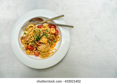 Top Down Flat Lay Image Of Spaghetti With Salmon, Cherry Tomatoes, Green Peas And Shrimp Fat Paste Topped With Grated Parmesan. A Delicious Italian Food Dish With Asian Touch