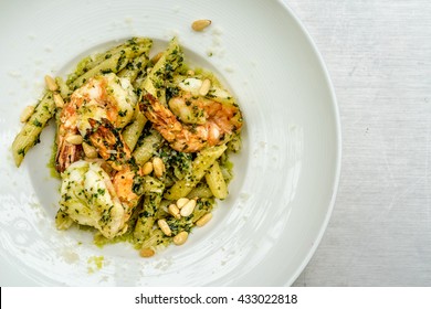 Top Down Flat Lay Image Of Penne Spaghetti With Tiger Prawn, Pesto Sauce, And Shrimp Fat Paste Topped With Grated Parmesan And Sunflower Seeds. A Delicious Italian Food Dish With Asian Touch