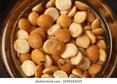 Top down flat lay view of split peas chana buter dal in mini glass jar on dark black slate background