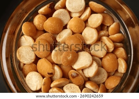 Top down flat lay view of split peas chana buter dal in mini glass jar on dark black slate background