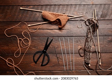 Top Down Flatlay Of Wool And Knitting Supplies On Dark Wooden Background, Copy Space