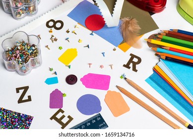 Top Down Image Of Various Crafting/ Mixed Media/ Scrapbooking Art Supplies In Bright Colors Against A White Background. 